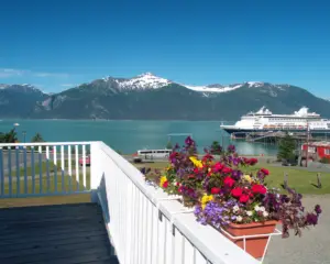 Looking across the bay at Haines, AK with a small cruise ship in the bay and snow-capped mountains in the background.